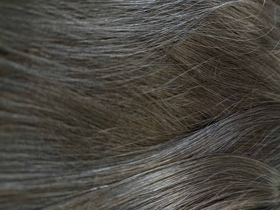 Close-up of black hair extensions with clips on a white background