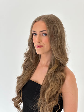 Woman with long, wavy brown hair against a white background