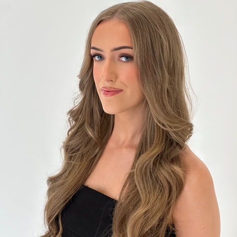 Woman with long, wavy brown hair against a white background