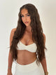 Woman wearing a white bikini top against a plain background